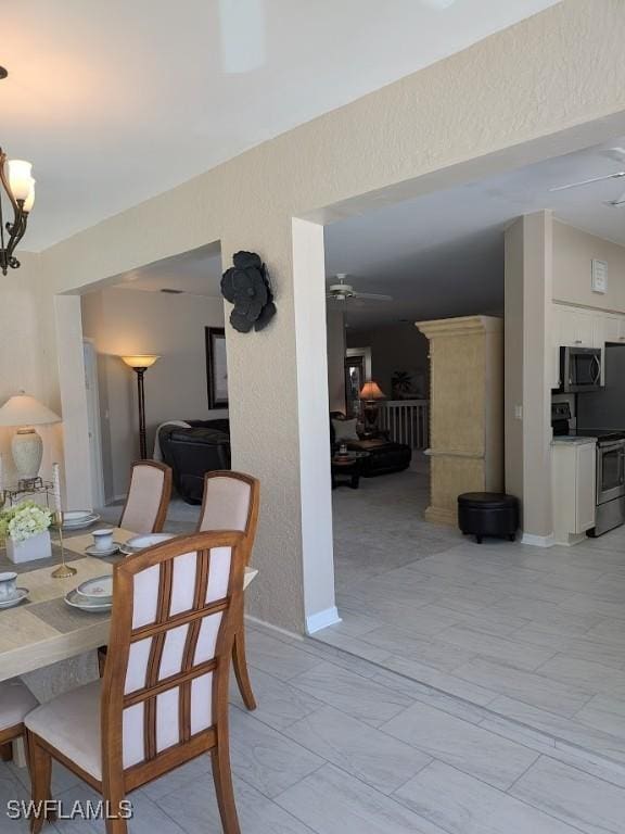 dining area with ceiling fan with notable chandelier