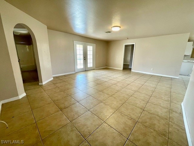 unfurnished room featuring french doors