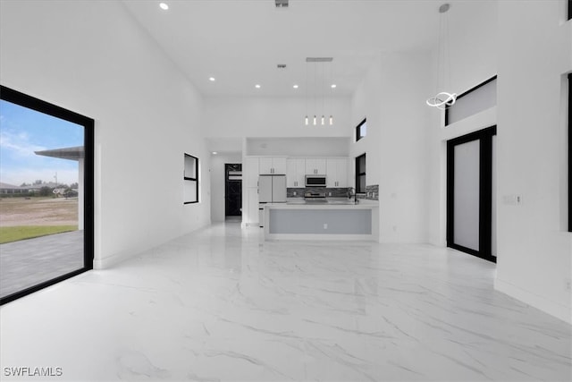 unfurnished living room featuring sink and a high ceiling