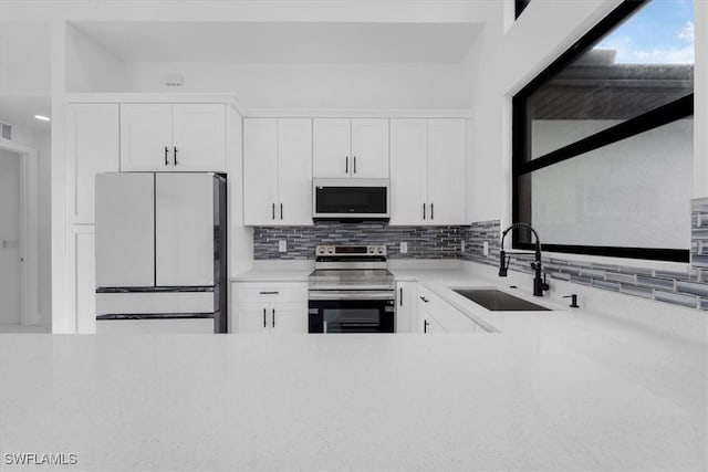 kitchen with decorative backsplash, white cabinets, sink, and white appliances