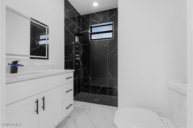 bathroom featuring toilet, vanity, and a tile shower