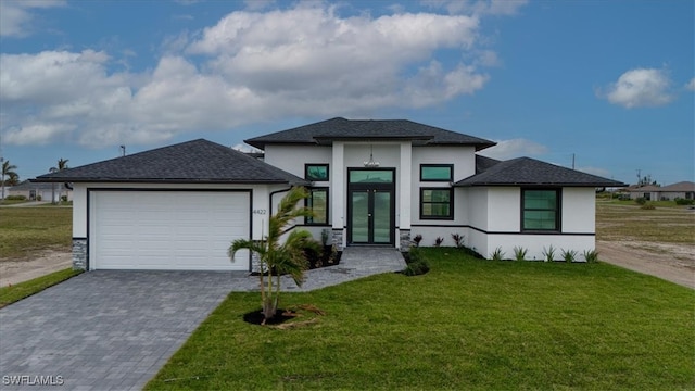 prairie-style home featuring a garage and a front lawn