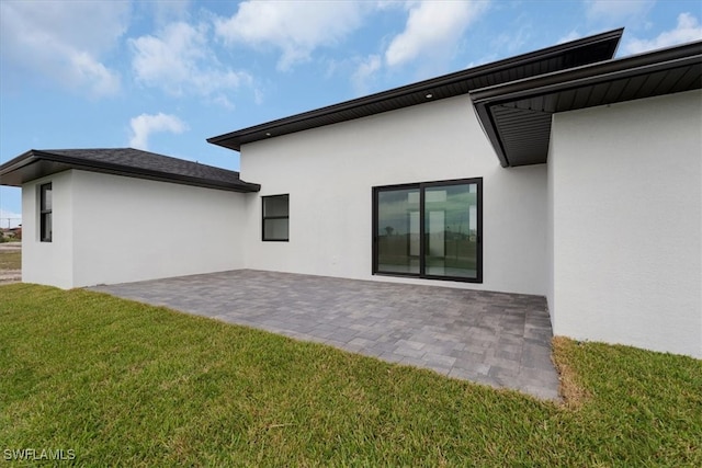 back of property featuring a yard and a patio