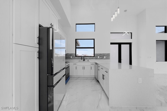 kitchen featuring white cabinetry, hanging light fixtures, stainless steel appliances, and kitchen peninsula