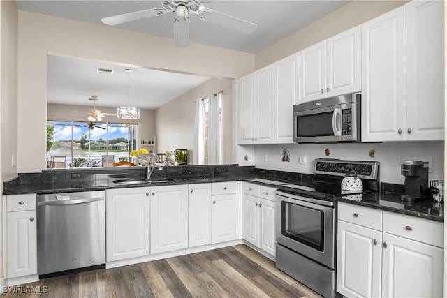 kitchen with stainless steel appliances, sink, backsplash, white cabinets, and dark hardwood / wood-style flooring