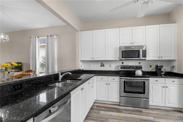 kitchen with white cabinets, appliances with stainless steel finishes, sink, and light hardwood / wood-style flooring