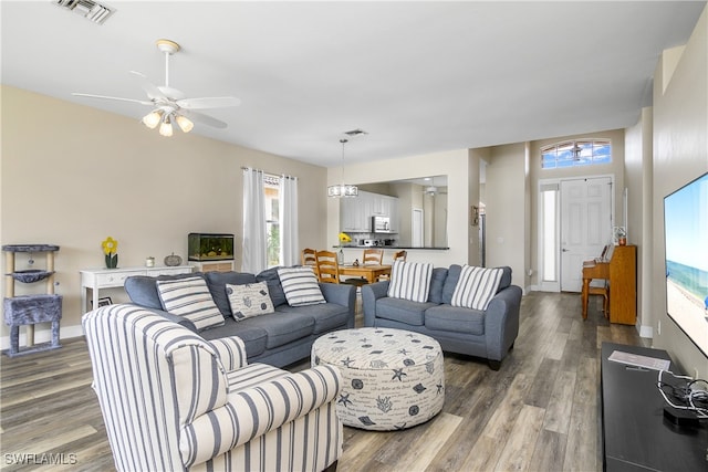 living room featuring hardwood / wood-style floors and ceiling fan with notable chandelier