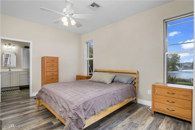 bedroom featuring ceiling fan, connected bathroom, sink, and dark hardwood / wood-style flooring