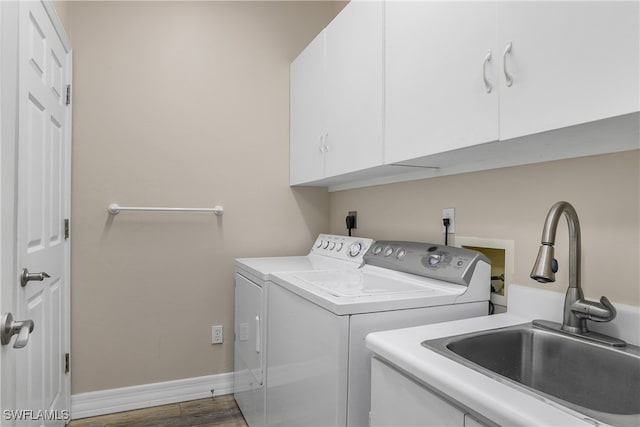 washroom with washer and clothes dryer, dark wood-type flooring, cabinets, and sink