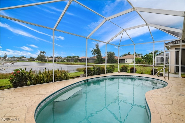 view of pool featuring glass enclosure, a patio area, and a water view