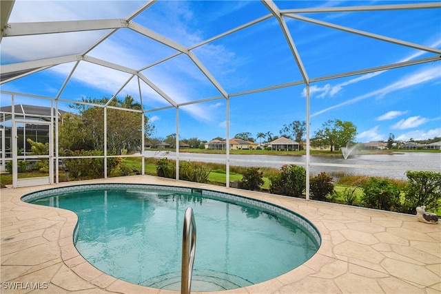 view of pool featuring glass enclosure, a water view, and a patio area