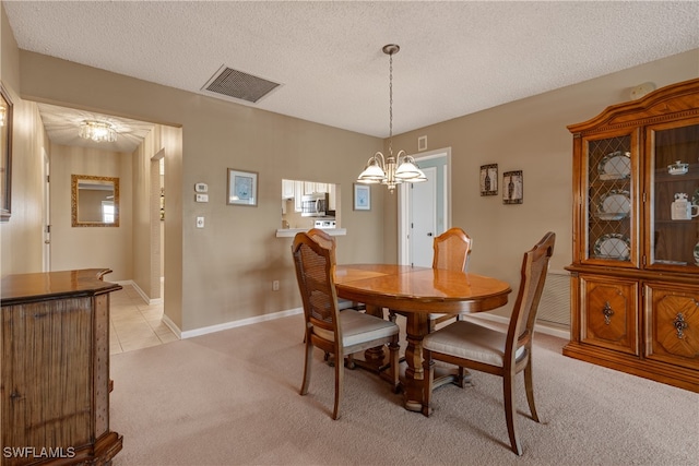 dining space with a textured ceiling, a chandelier, and light colored carpet