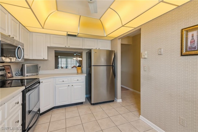 kitchen featuring light tile patterned floors, light countertops, baseboards, white cabinets, and appliances with stainless steel finishes