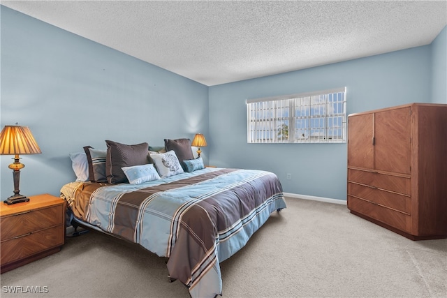 bedroom featuring light carpet and a textured ceiling