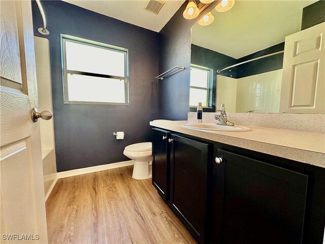 full bathroom featuring hardwood / wood-style flooring, vanity, bathtub / shower combination, and toilet