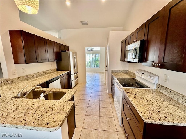 kitchen with stainless steel appliances, sink, and light stone counters