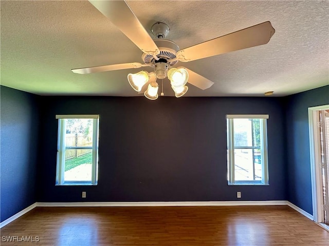 spare room with dark hardwood / wood-style flooring, a textured ceiling, and ceiling fan