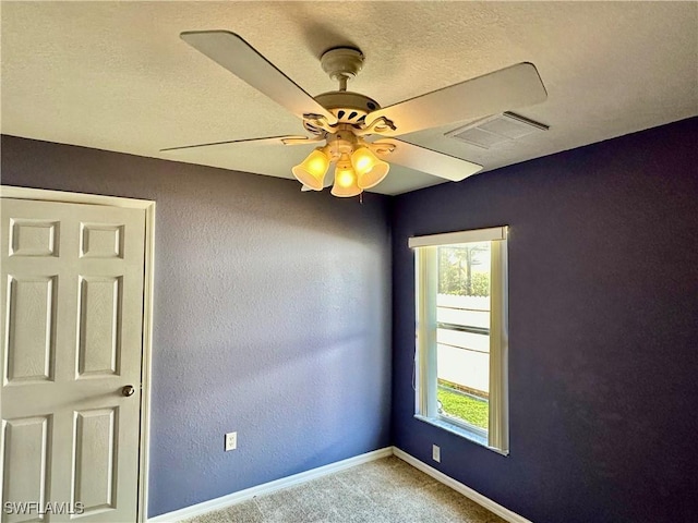 spare room with ceiling fan, carpet flooring, and a textured ceiling