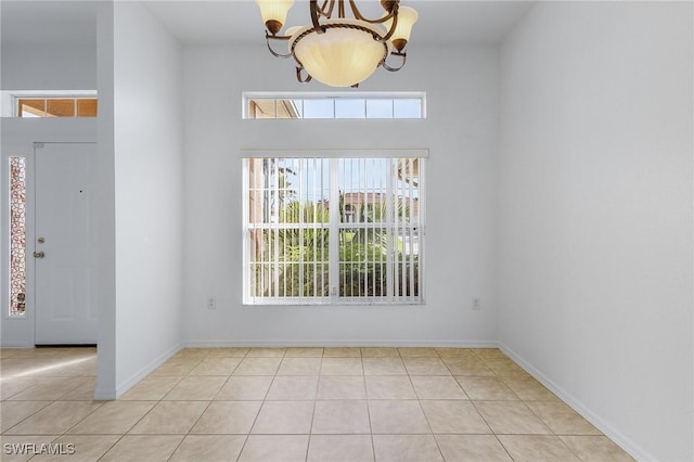 foyer entrance with light tile patterned floors and an inviting chandelier