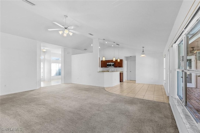 unfurnished living room with light carpet, high vaulted ceiling, and ceiling fan