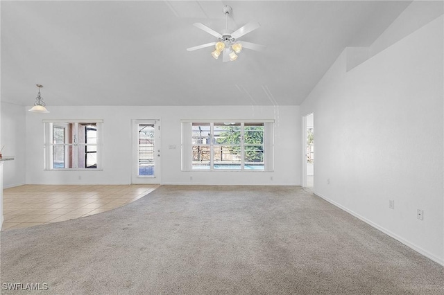 unfurnished living room with light carpet, ceiling fan, high vaulted ceiling, and a healthy amount of sunlight