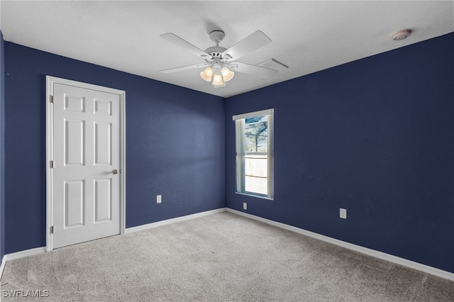 carpeted spare room featuring ceiling fan