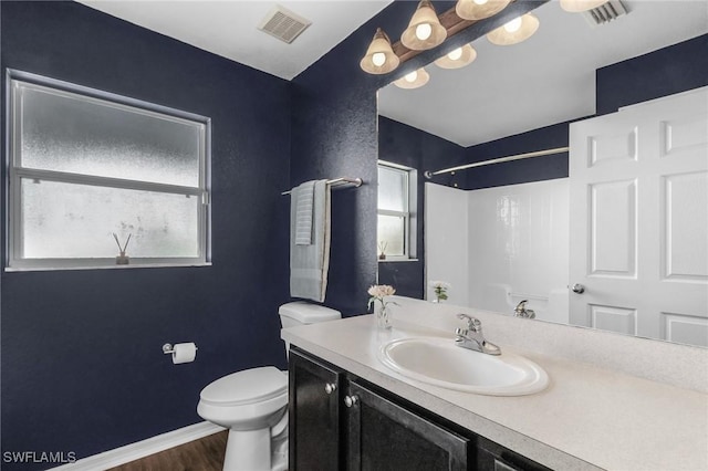 bathroom featuring vanity, hardwood / wood-style floors, toilet, and walk in shower