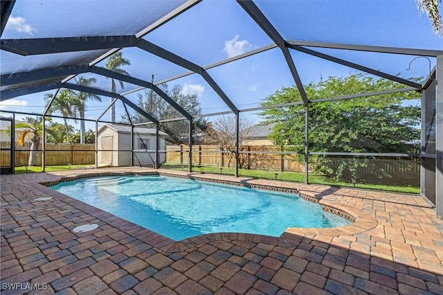 view of pool with a patio, a lanai, and a shed