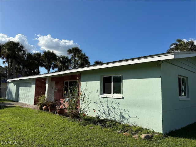 single story home featuring a front lawn and a garage