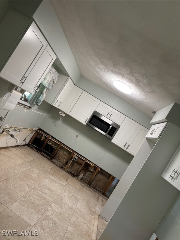 kitchen featuring white cabinets and light tile patterned floors