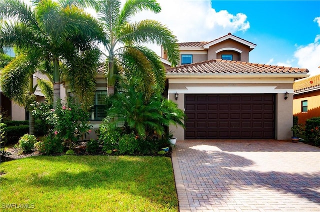 mediterranean / spanish home with a front yard and a garage