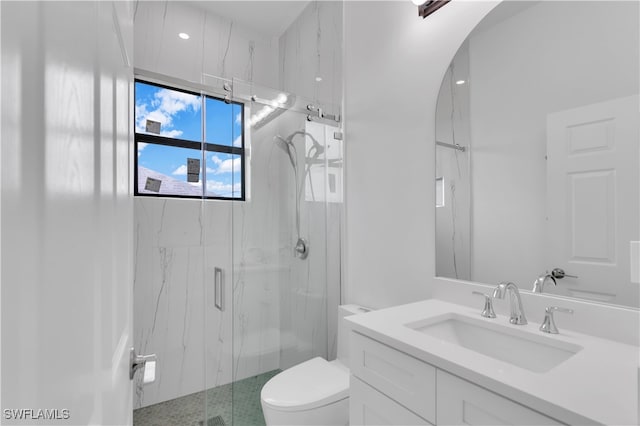 bathroom with a shower with door, vanity, and toilet