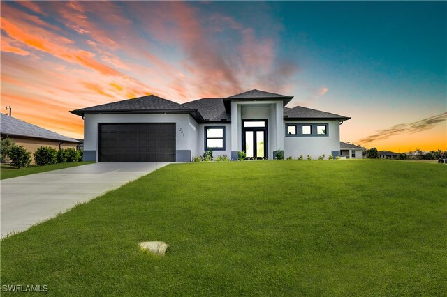 prairie-style home featuring a yard and a garage