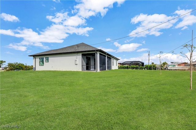 back of house with a sunroom and a lawn