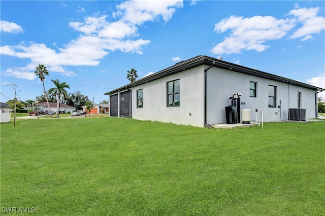 back of property with a yard and central air condition unit