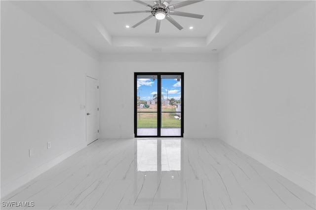 unfurnished room featuring ceiling fan and a tray ceiling