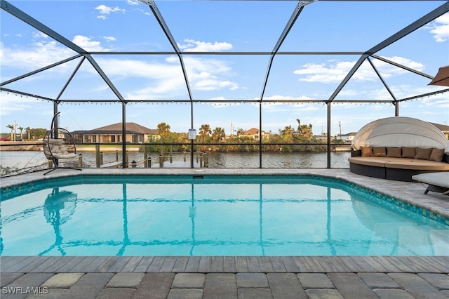 view of swimming pool with a patio area, glass enclosure, and a water view