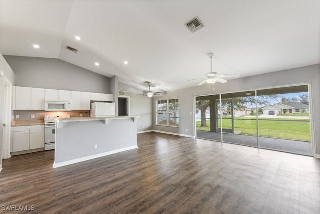 kitchen with a wealth of natural light, white cabinetry, dark hardwood / wood-style floors, and white appliances