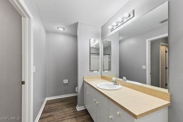 bathroom featuring toilet, hardwood / wood-style floors, and vanity