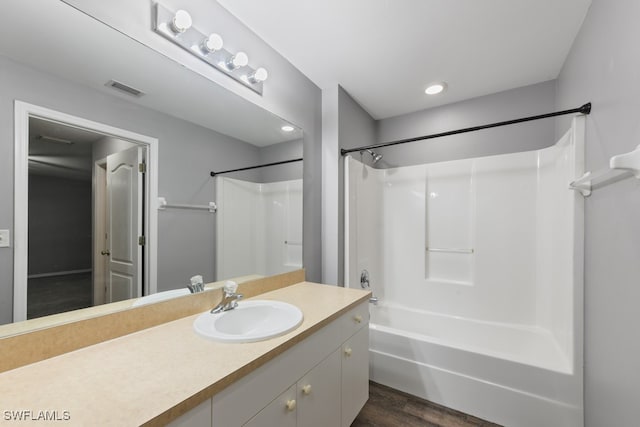 bathroom featuring vanity, wood-type flooring, and bathing tub / shower combination