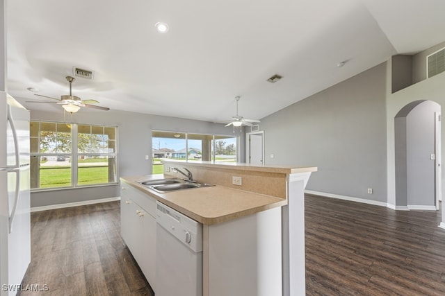 kitchen featuring dark hardwood / wood-style floors, an island with sink, sink, vaulted ceiling, and white appliances