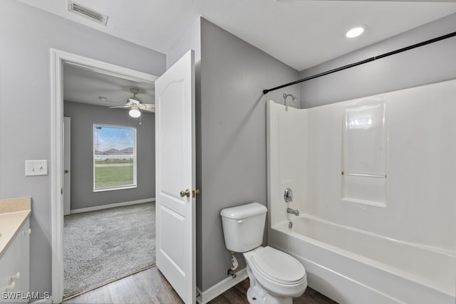 full bathroom with toilet, shower / tub combination, wood-type flooring, vanity, and ceiling fan