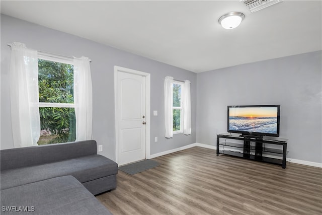 living room featuring dark wood-type flooring and a healthy amount of sunlight