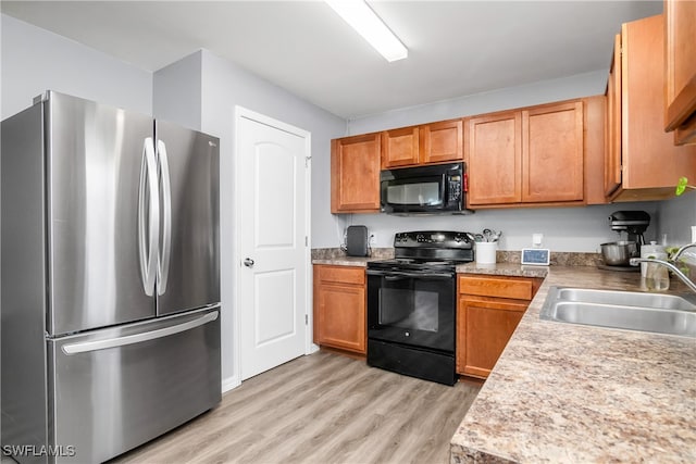 kitchen featuring light wood-type flooring, sink, and black appliances