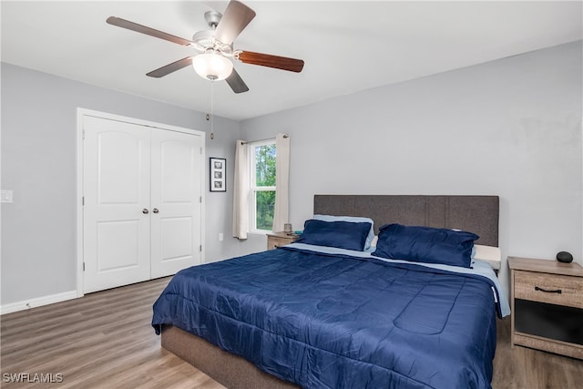 bedroom with hardwood / wood-style flooring, ceiling fan, and a closet