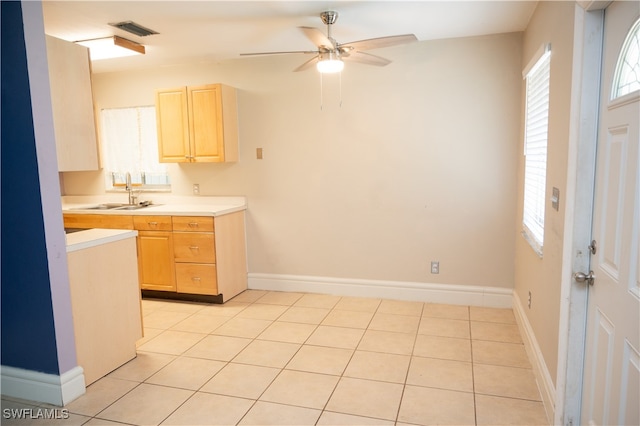 kitchen featuring light brown cabinetry, sink, and light tile patterned floors