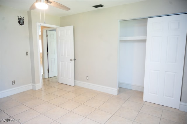 unfurnished bedroom featuring light tile patterned floors, a closet, and ceiling fan