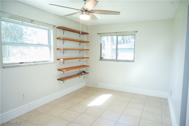 tiled spare room with ceiling fan