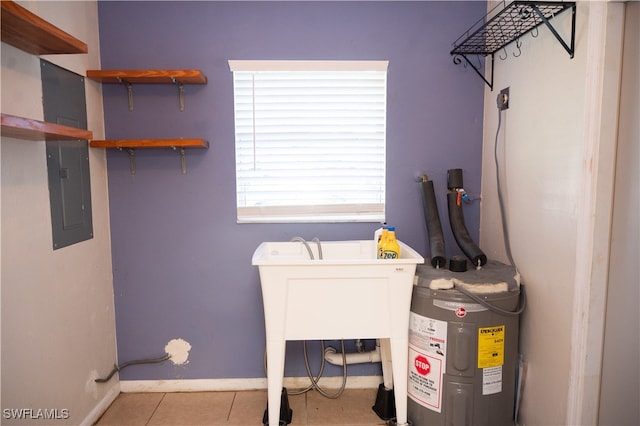 laundry area with water heater and light tile patterned floors