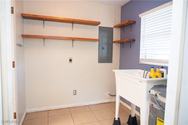 washroom featuring hookup for an electric dryer, water heater, electric panel, and light tile patterned floors